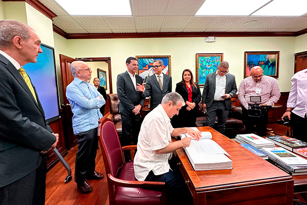 El Dr. Santos Gracia firmando el libro de visitas del MESCYT.